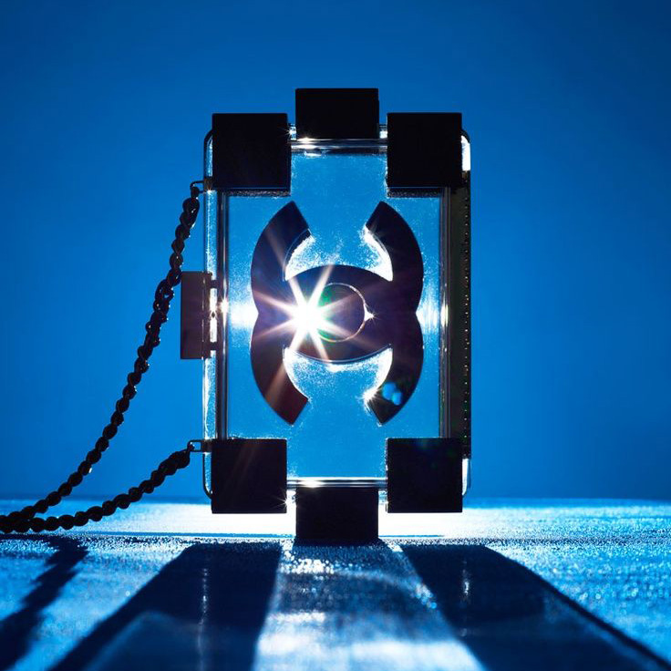 chanel lego designer handbag in plexi glass and black against blue background