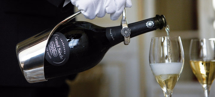 butler pouring the champagne in a flute glass
