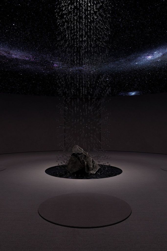 An artistic underground meditation room featuring a starry sky ceiling and a central water feature surrounded by a rock.