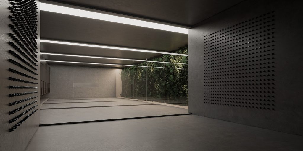 Interior view of an underground space featuring a glass wall with greenery, concrete floors, and modern lighting.