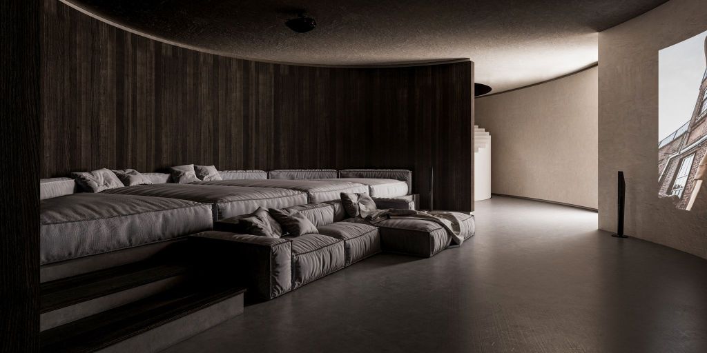 A cozy, modern living room area with layered, plush seating against dark wooden walls, featuring a minimalist design and a projection screen on one side.