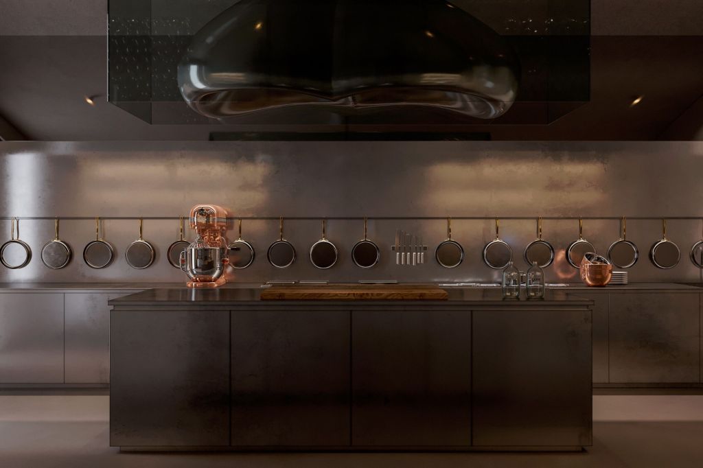 Modern kitchen with stainless steel surfaces, featuring a central island and hanging cookware. A copper mixer is prominently displayed, adding a touch of elegance.
