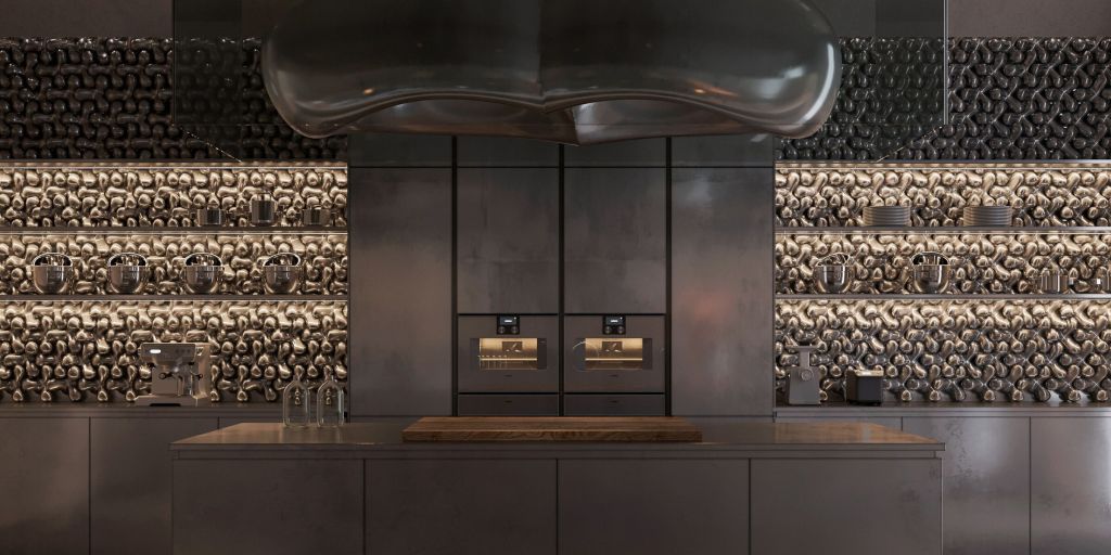 A modern kitchen featuring a sleek design with metallic surfaces, equipped with appliances and a decorative wall displaying a unique textural pattern.