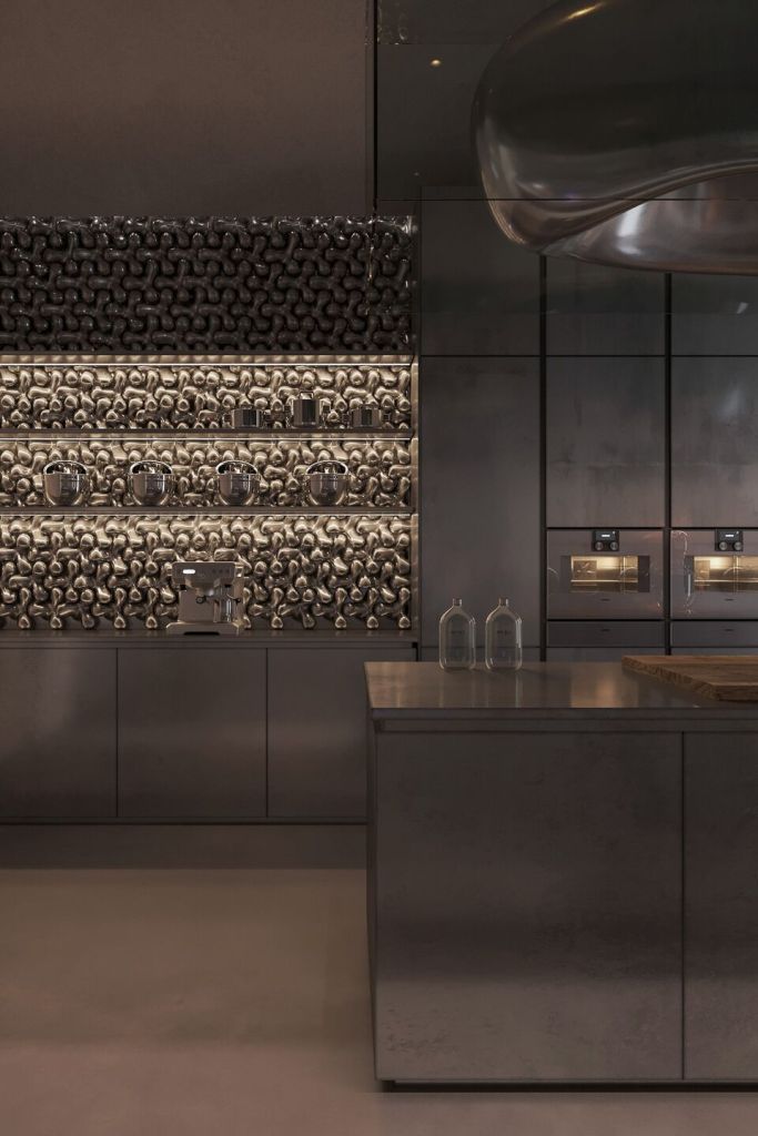 Modern kitchen with stainless steel surfaces and appliances, featuring unique textured wall panels and elegant lighting.