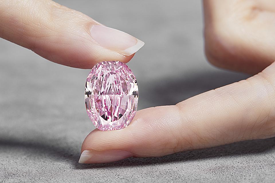 rare pink diamond in the hand of a woman