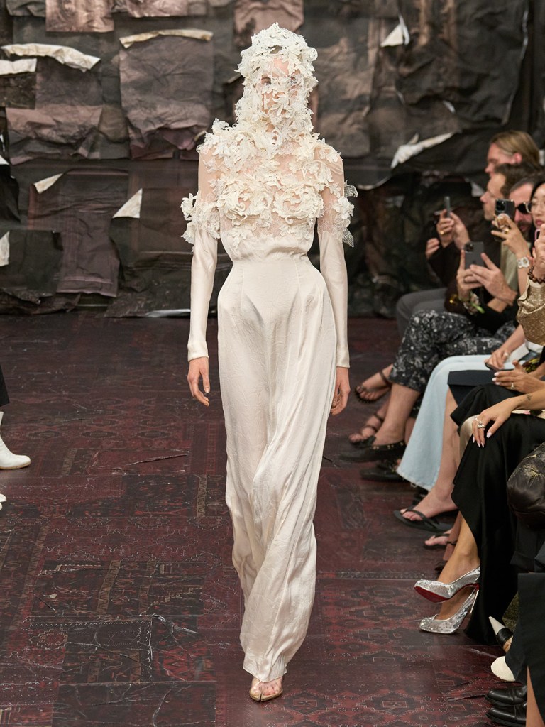 model showcases silkly cream colour dress featuring 3d roses on the upper body