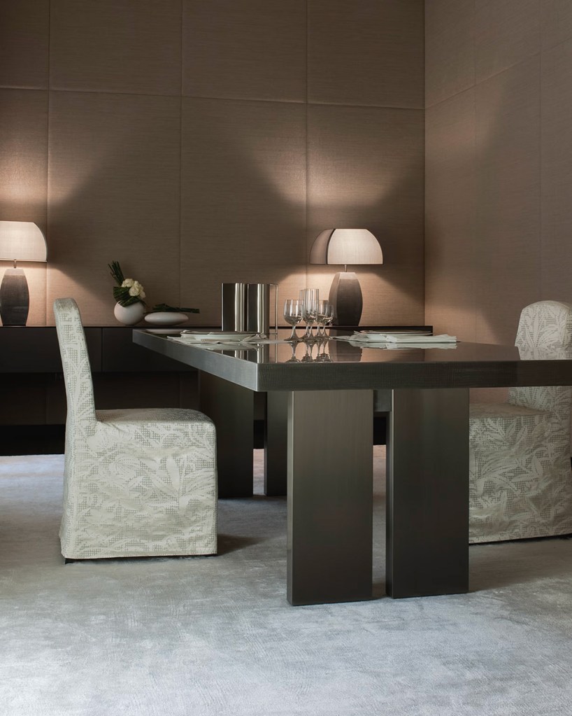 An elegant dining area for two people with wine glasses and napkins on the table.