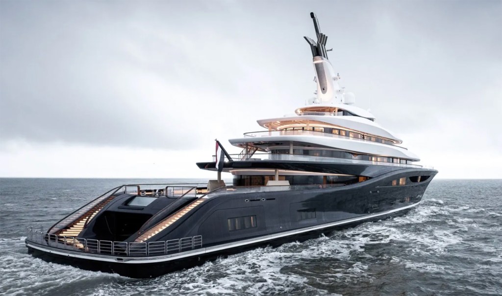 Luxurious yacht sailing in open waters under a cloudy sky. The sleek black hull and modern design evoke elegance and sophistication.
