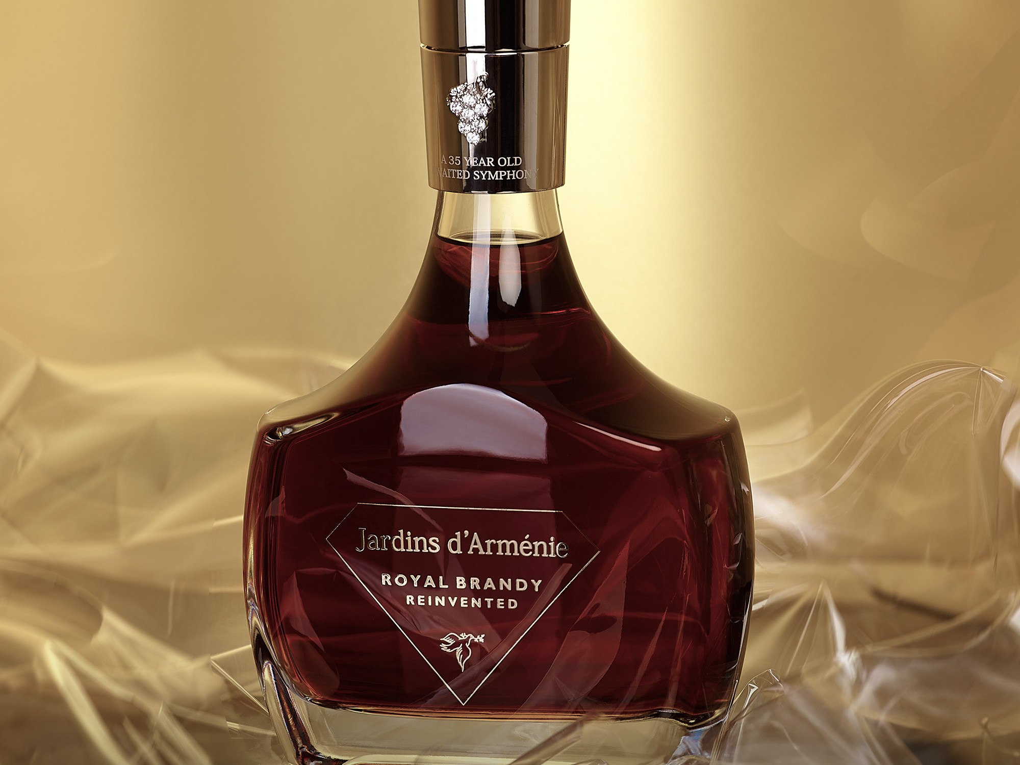 Ornate, dark glass bottle of Jardins d'Arménie brandy against a golden background, exuding elegance and luxury; rich, inviting tones.