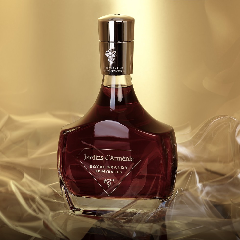 Ornate, dark glass bottle of Jardins d'Arménie brandy against a golden background, exuding elegance and luxury; rich, inviting tones.