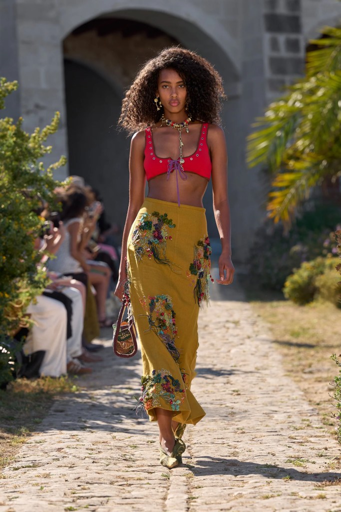 Alémais model wears red bra with khaki green long skirt