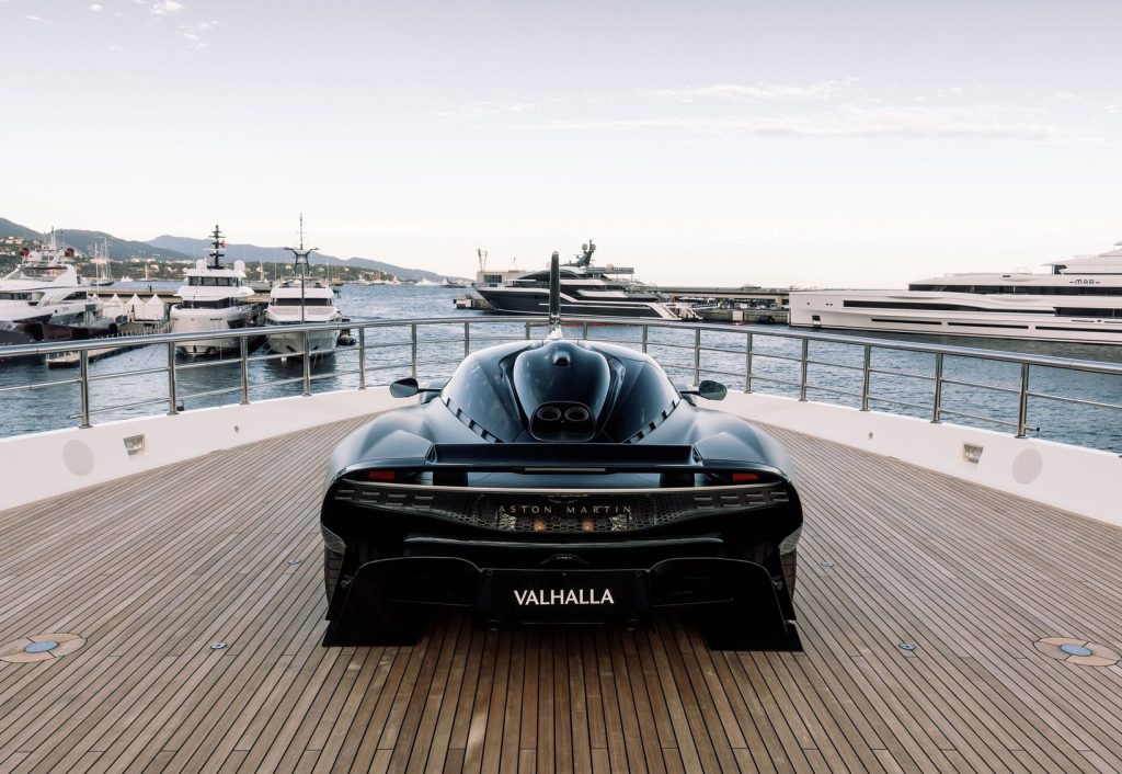 Black Aston Martin hypercar on luxury yacht deck
