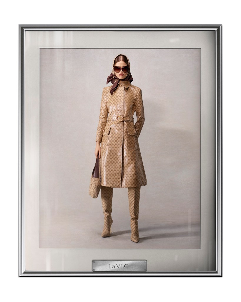 La V.I.C brunette models wears shiny trench coat, silk scarf and bag with Gucci monogram