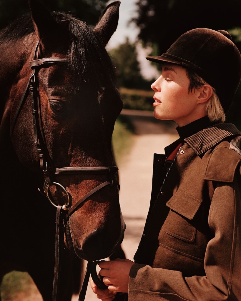 Face of woman close to brown horse.