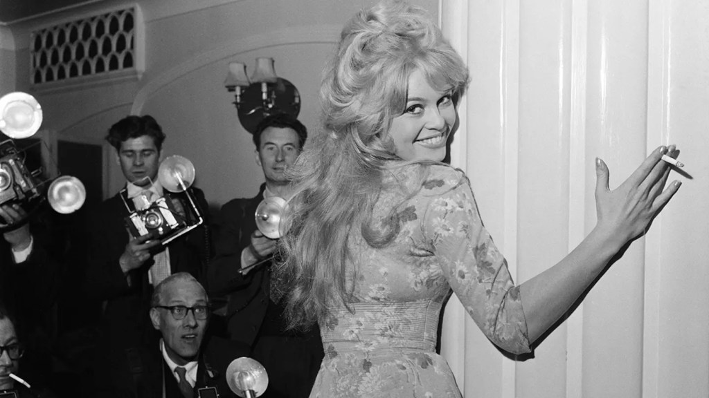Brigitte Bardot posing for paparazzi and photographers with cigarette in hand