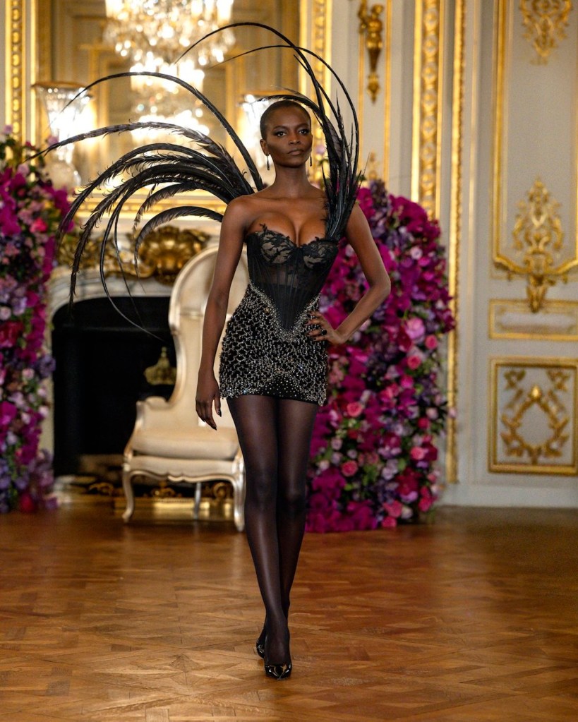 black model wears short dress with feathers