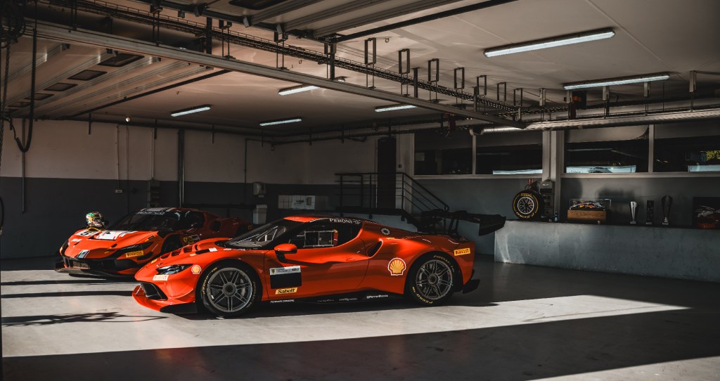 Two red Ferrari supercars in garage