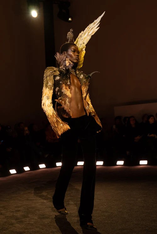 black model wears Schiaparelli haute couture 2026 black pants and bird feather jacket