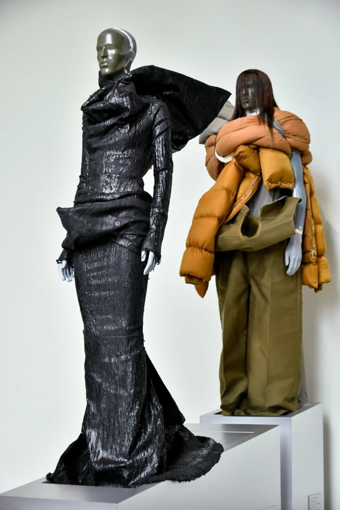 Rick Owens exhibition in Paris featuring shiny black dress and puffy jacket in olive green and shades of orange