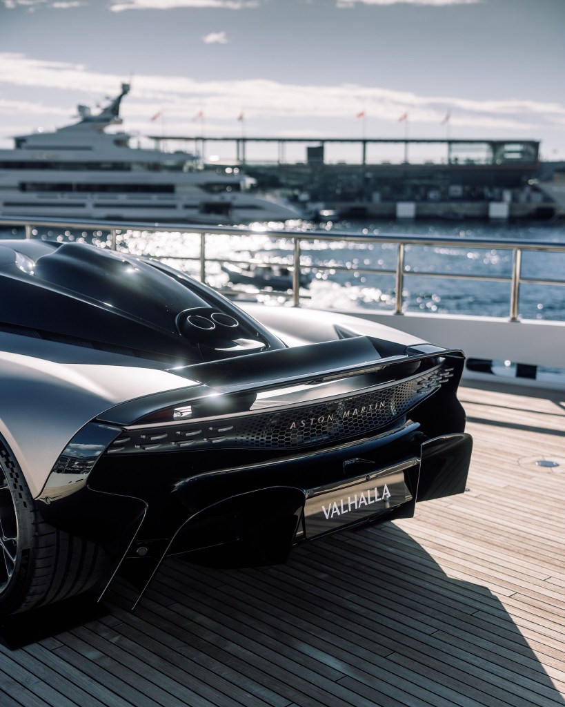 Aston Martin Valhalla near luxury yacht.