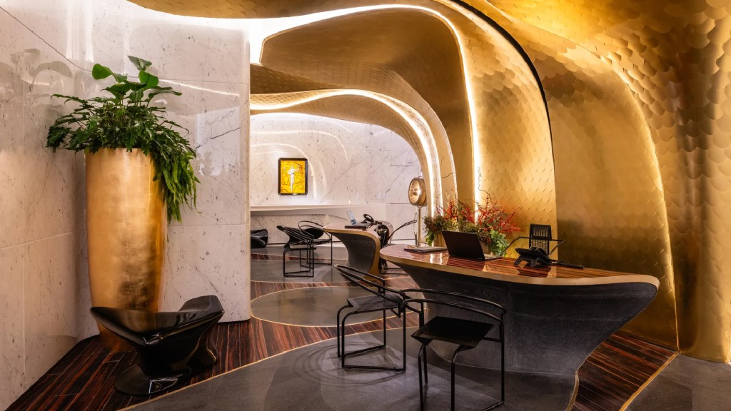 Hotel Romeo Roma chic reception with golden design walls