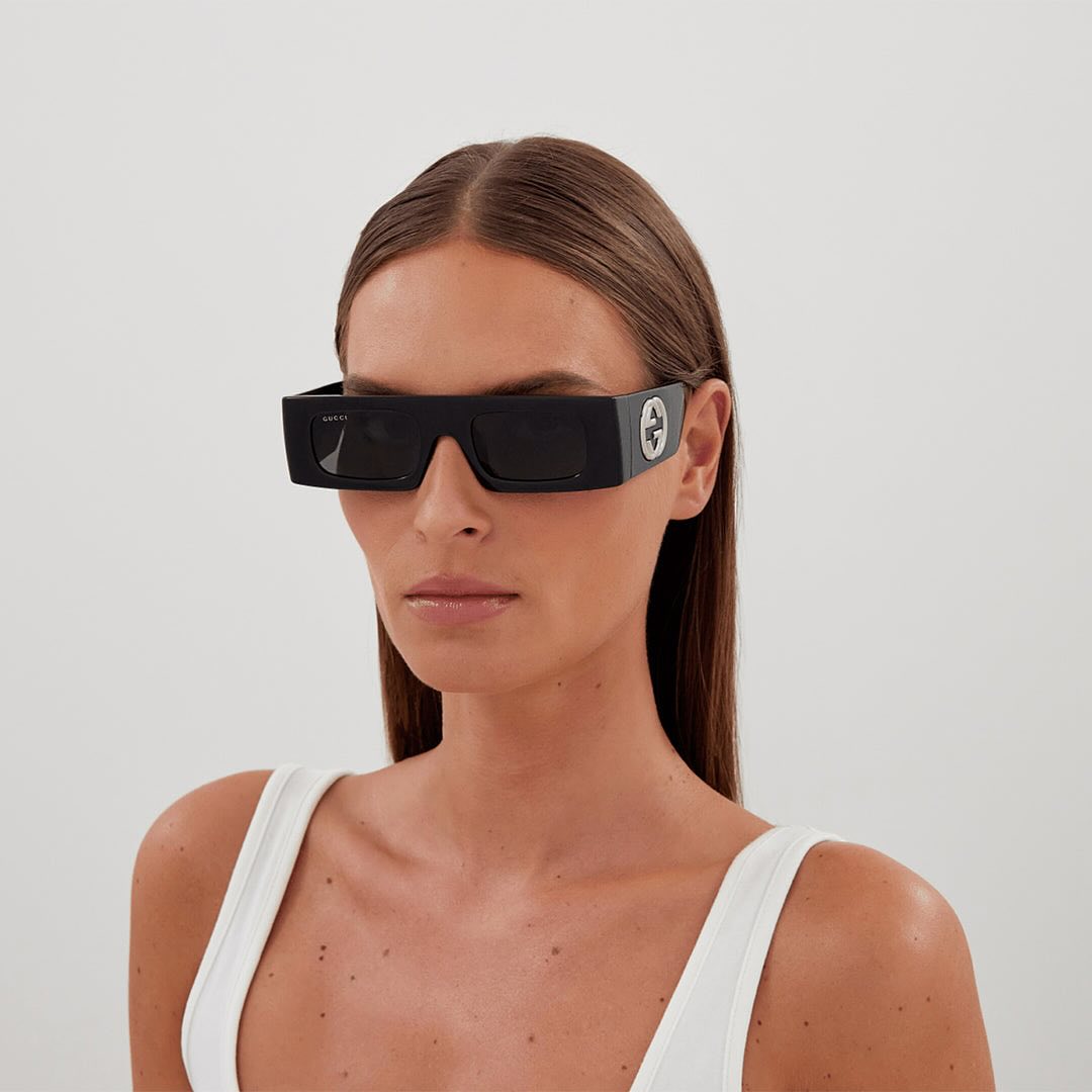 gucci 3d black logo sunglasses on a young female models in a whit tank top